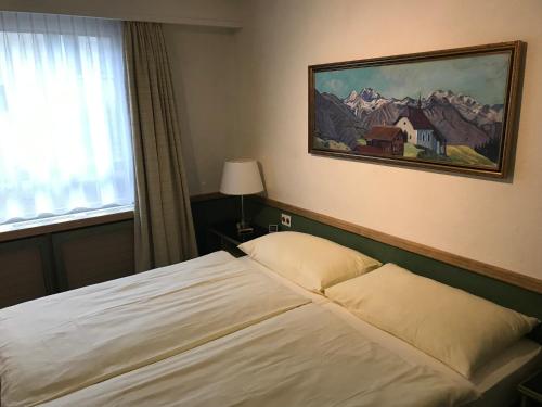 Un dormitorio con una cama y un cuadro en la pared. en Hotel Arlette Beim Hauptbahnhof, en Zúrich