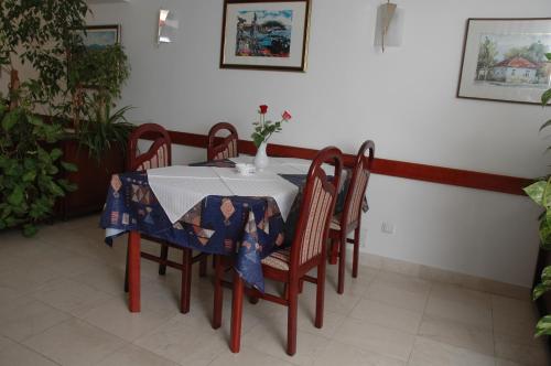 a table and chairs with a table and a vase on it at Vila Lux Milikic in Kraljevo