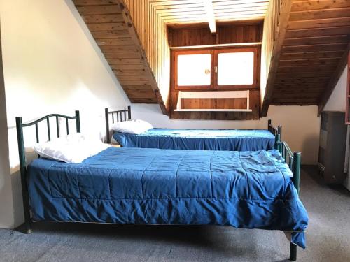2 camas con sábanas azules en una habitación en Casa Damiana Bariloche. en San Carlos de Bariloche