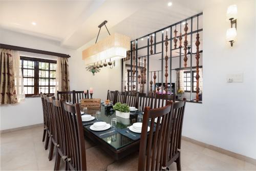 a dining room with a glass table and chairs at Lavish Executive Villa with Private Swimming Pool in Calangute