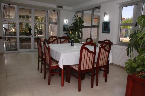 a dining room with a white table and chairs at Vila Lux Milikic in Kraljevo