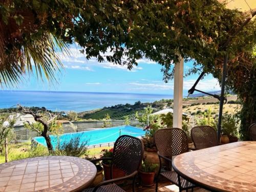 a patio with a table and chairs and a pool at B&B Villa Sveva in Rocca Imperiale