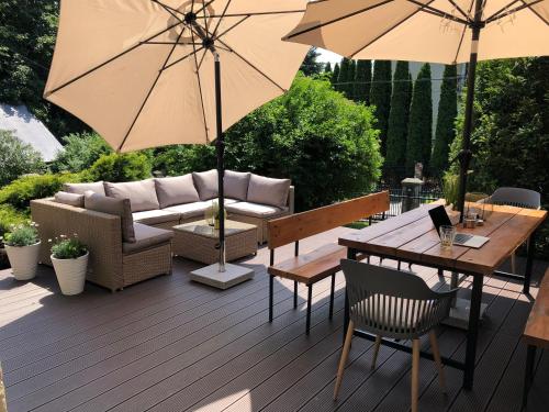 a patio with a couch and a table with an umbrella at Ośrodek Sportowo-Rekreacyjny Słoneczny in Mszana Dolna