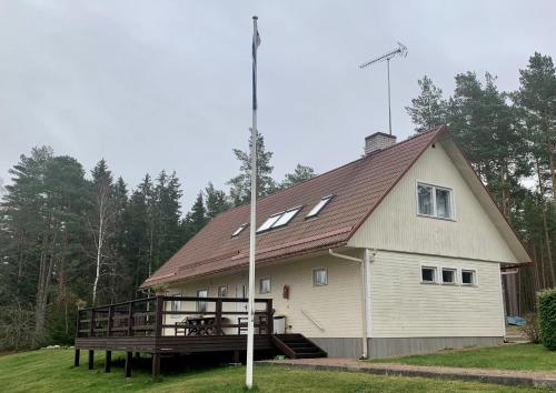 a large house with a gambrel roof with a deck at Holiday Home Veskijõe in Vaisi