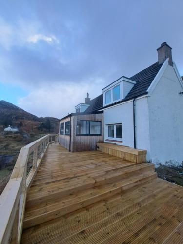 a wooden deck in front of a house at NC500 - Modern croft house at Handa HI-00734-F in Scourie