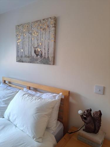 a bedroom with a bed and a painting on the wall at NC500 - Modern croft house at Handa HI-00734-F in Scourie