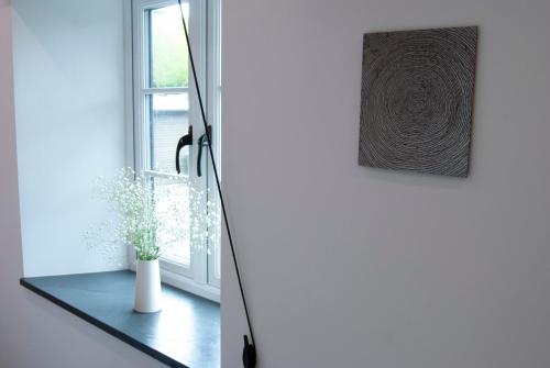 a door with a vase on a table next to a window at Lower Winsford Apartments & Rooms in Bideford