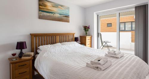 a bedroom with a white bed with towels on it at Plover 3 - The Cove in Brixham