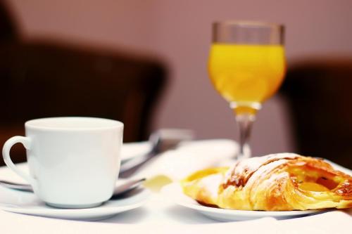 a table with a plate of food and a glass of orange juice at Hotel Shine Palace in Tbilisi City