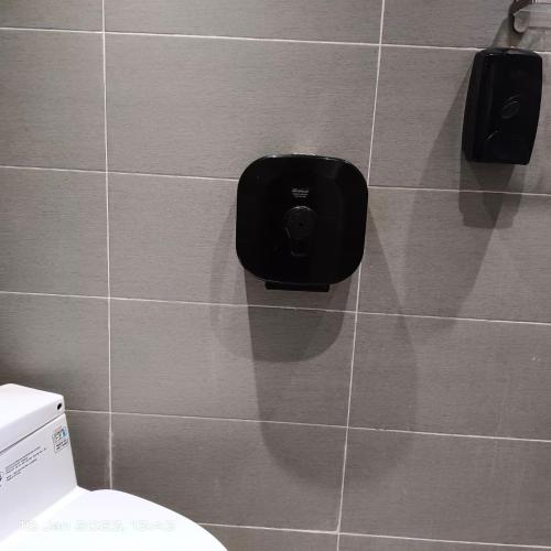 a bathroom with a toilet in a tiled wall at Cheras Homestay Family room with Private Bathroom in Kuala Lumpur
