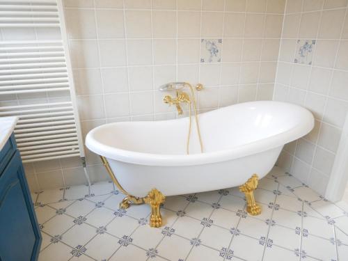 a white tub in a bathroom with a tiled floor at Buitenplaats 108 in Callantsoog