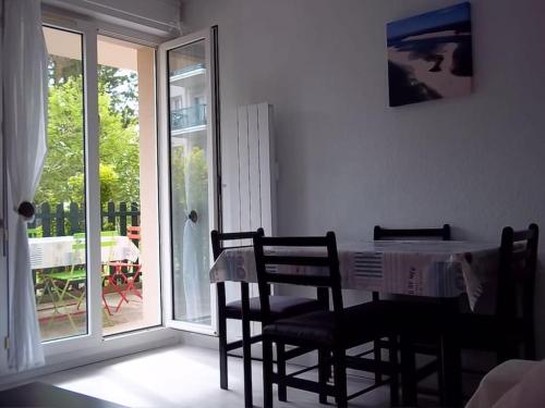 a dining room with a table and chairs and a balcony at Arcachon T2 Calme proche plages et commerces et 2 vélos in Arcachon