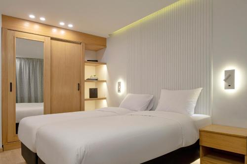 Un dormitorio con una gran cama blanca y una ventana en Parkside Boutique Furnished Apartments en El Cairo