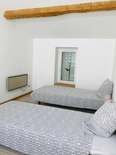 sypialnia z dwoma łóżkami i oknem w obiekcie Aux Gunes w mieście Cissac-Médoc