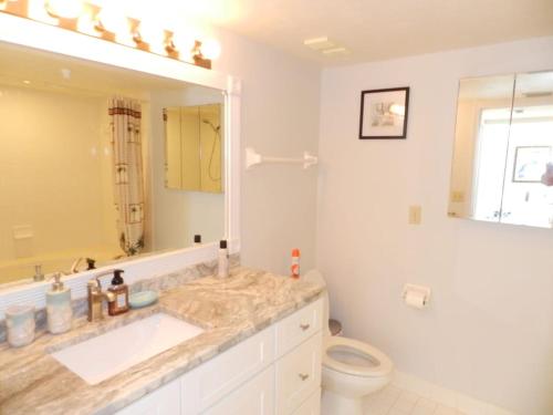 y baño con lavabo, aseo y espejo. en "SHERWIN" Coastal Vibes Oceanfront Condominiums en Daytona Beach