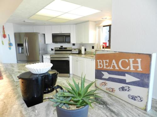 een keuken met een strandbord op het aanrecht bij "SHERWIN" Coastal Vibes Oceanfront Condominium 301 in Daytona Beach