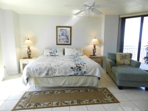 1 dormitorio con 1 cama y 1 silla azul en "SHERWIN" Coastal Vibes Oceanfront Condominiums en Daytona Beach