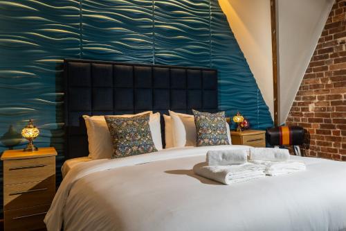 a bedroom with a large bed with a blue wall at Marine Lodge in Great Yarmouth