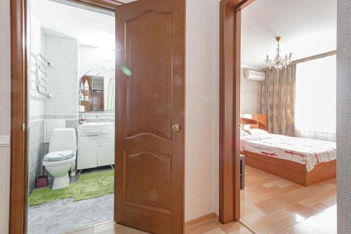 a room with a bedroom with a bed and a bathroom at Уютная квартира in Astana