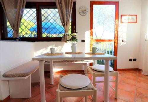 - une table et des chaises dans une chambre avec fenêtre dans l'établissement RELAX MARGHERITA, à Colli di Fontanelle