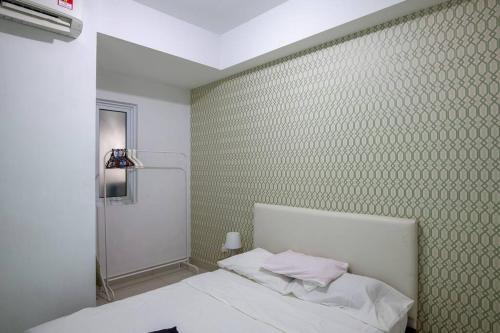 a bedroom with a white bed and a green wall at 2bedrooms Maritime Seaview Luxury Suite 2Carpark 2-9pax in Jelutong