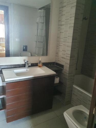 a bathroom with a sink and a toilet and a tub at LES Dunes De Faqra ( c duplex ) in Abū Mīzān