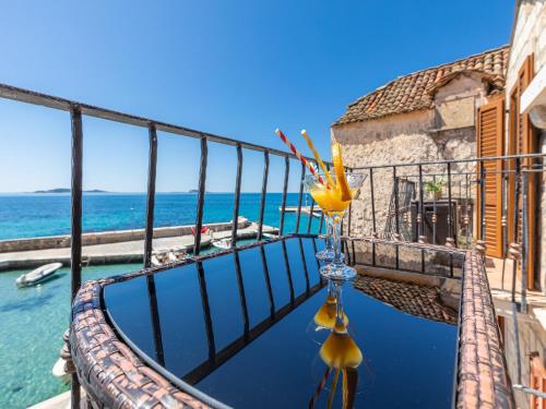 a vase with flowers on a balcony overlooking the water at Villa Ana Apartments in Mlini