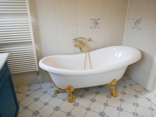 a white tub in a bathroom with a tiled floor at Villa Buiten 108 in Callantsoog