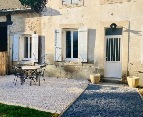 a table and chairs in front of a building at Appartement Riquet - centre ville, rdc, climatisé, jardin, parking privée in Castelnaudary