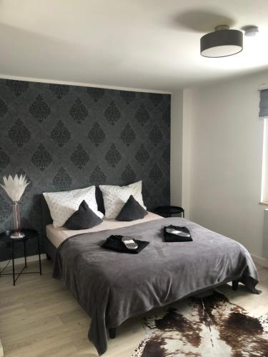 um quarto com uma cama com duas toalhas pretas em Body Kult Loft - Modernes Appartement mit 2 separaten Schlafzimmern em Zwickau