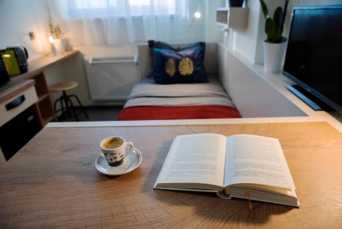 un libro abierto y una taza de café sobre una mesa en Studio u Horynů - Hýblova en Česká Třebová