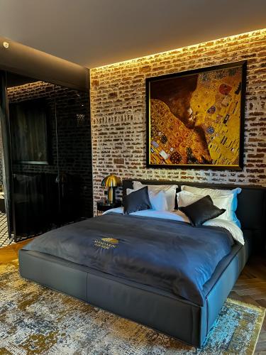 a large bed in a room with a brick wall at Mandarin Club House in Batumi