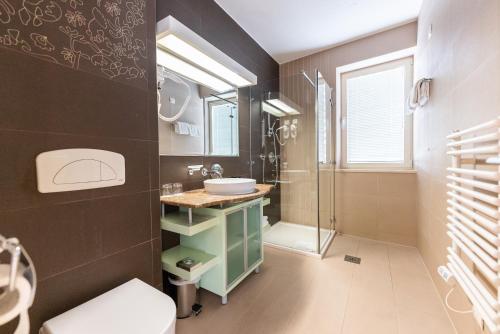 La salle de bains est pourvue d'un lavabo et d'une douche. dans l'établissement Boutique Hotel Portorose, à Portorož