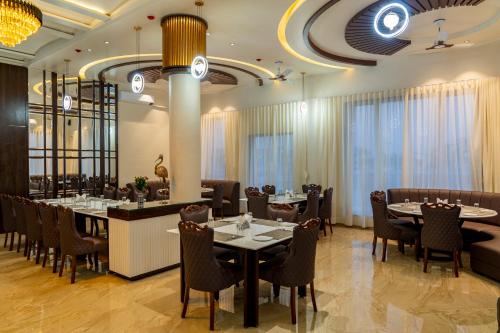 a restaurant with tables and chairs and a bar at Flamingo Club and Resort Una 3 Km Away from Diu Check Post in Diu