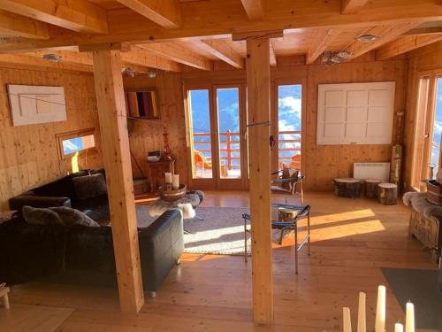a living room with wooden floors and a large room with windows at Chalet , Thyon Les Collons, 4 Vallées in Les Collons