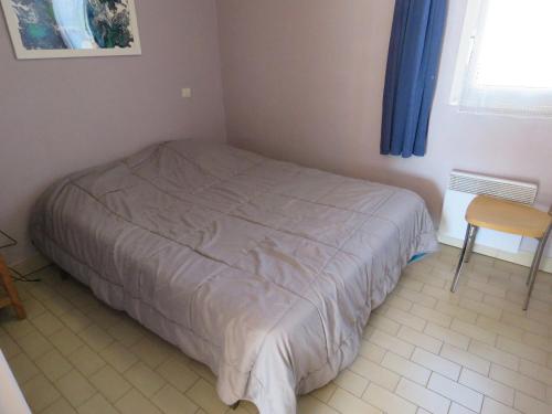 une petite chambre avec un lit et une chaise dans l'établissement T2 à Sète, 30m², Vue Mer, Parking Privé - FR-1-472-134, à Sète