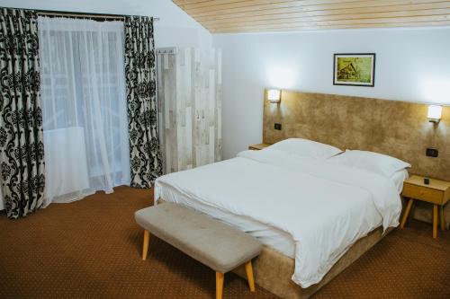 sypialnia z dużym białym łóżkiem i oknem w obiekcie Domeniul CRIS Vatra Dornei w mieście Vatra Dornei