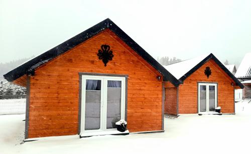 a small wooden building with two windows in the snow at Spiska Dolina in Łapsze Niżne