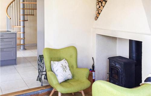 un salon avec une chaise verte et une cheminée dans l'établissement 4 Bedroom Cozy Home In Monfaucon, à Monfaucon