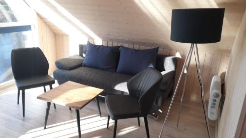 a living room with a couch and two chairs at Ferienhaus mit Wasserterrasse - mit Sauna und Kamin - inklusive Nebenkosten in Wendisch Rietz