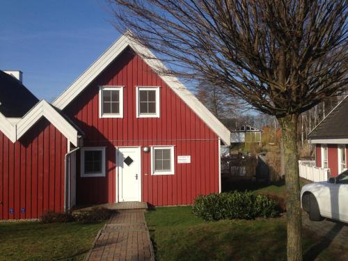 un granero rojo con una puerta blanca en un patio en Ferienhaus mit Wasserterrasse - mit Sauna und Kamin - inklusive Nebenkosten, en Wendisch Rietz