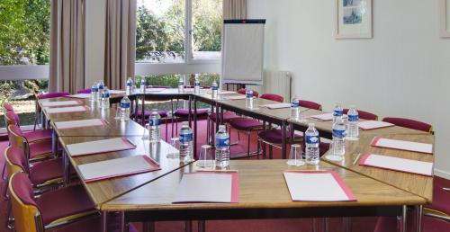 a conference room with tables and chairs and water bottles at Hotel Belambra Le Normont in Dourdan