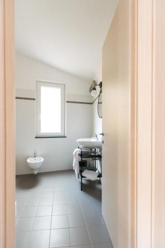 a white bathroom with a sink and a window at Affittacamere Le Giare in Riomaggiore