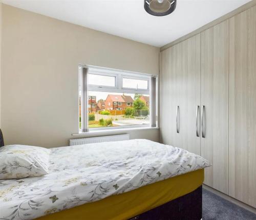 a bedroom with a large bed and a window at Mordern home in Kippax