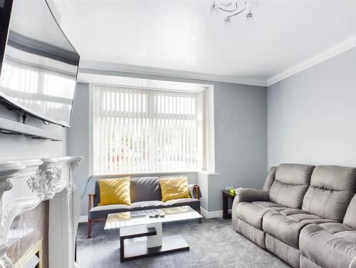 uma sala de estar com um sofá e uma lareira em Mordern home em Kippax