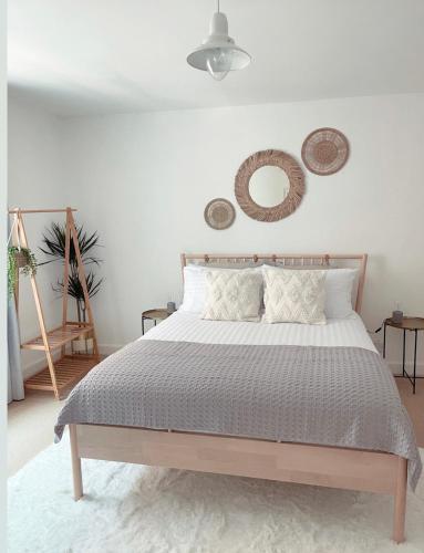 a bedroom with a bed and two mirrors on the wall at Seapink, Kingsand; luxury Cornish cottage with seaviews, bbq & paddleboards in Kingsand