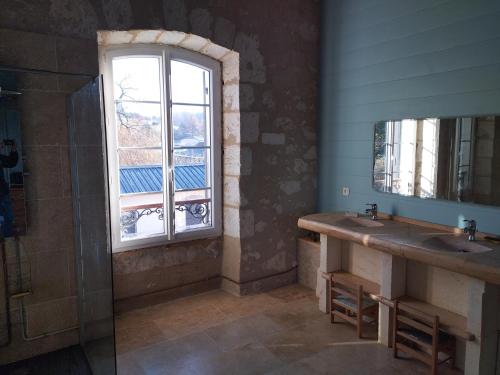 a bathroom with two sinks and a window at A la Gare in Saint-Nexans