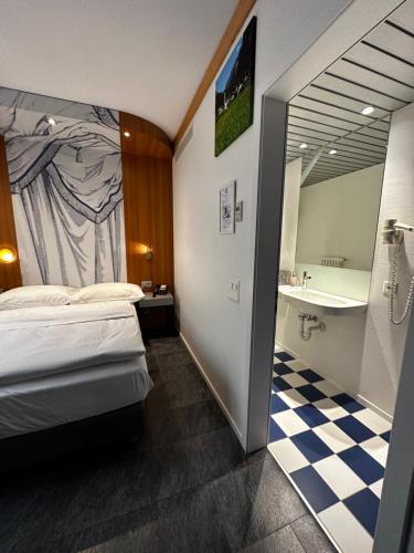a hotel room with a bed and a bathroom at Albergo Carcani by Ketty & Tommy in Ascona