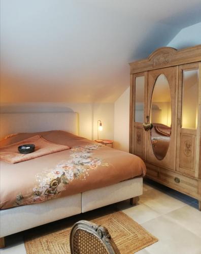 a bedroom with a bed and a wooden cabinet at Roos 14, sfeervol vakantieverblijf in hartje Hageland in Kortenaken