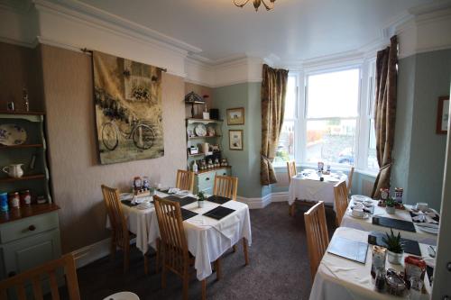un comedor con mesas y sillas y una ventana en Eden Green Guest House, en Keswick
